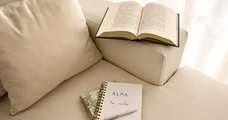 Cuaderno con la frase “ALMA ha vuelto” junto a un libro abierto en un rincón de lectura.